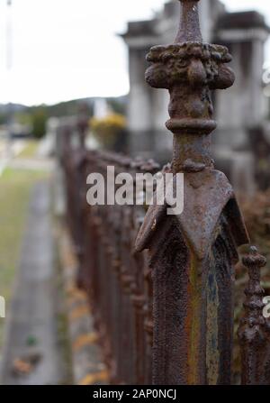 Recinzione arrugginita in un cimitero Foto Stock