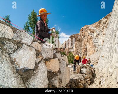 Costruzione di strade a Karakorum Highway da parte di lavoratori cinesi, la costruzione di un muro di roccia Foto Stock