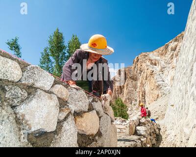 Costruzione di strade a Karakorum Highway da parte di lavoratori cinesi, la costruzione di un muro di roccia Foto Stock