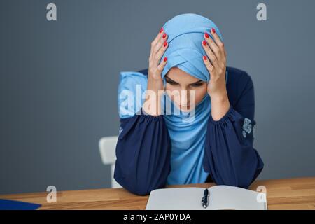 Infelice femminile musulmano apprendimento dello studente a casa Foto Stock