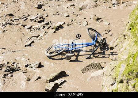 Bicicletta da bambino scaricata sul fiume di marea fango del fiume Mersey, vicino a Widnes, Cheshire. Foto Stock