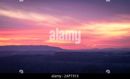 Un colorato tramonto invernale sulla valle di Avon con la scarpata del Cotswold in lontananza. Foto Stock