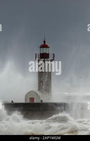 Porto, Portogallo - 7 Febbraio 2016: persone negligente nel mezzo della tempesta di mare. Fiume Douro bocca vecchio faro. Foto Stock