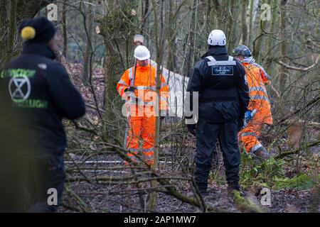 Harefield, UK. Il 20 gennaio, 2020. Gli appaltatori e l'esecuzione agenti che agiscono per conto di HS2 immettere la strada Harvil la tutela della fauna selvatica camp che fu rioccupata dagli attivisti dalla ribellione di estinzione, Stop HS2 e salvare il Colne Valley due giorni in precedenza. Alcuni attivisti, che cercano di proteggere antichi boschi minacciato dal collegamento ferroviario ad alta velocità, erano state sfrattate dal campo nel corso delle due settimane precedenti. Credito: Mark Kerrison/Alamy Live News Foto Stock