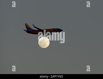 Un aereo della Southwest Airlines Boeing 737-700 atterra su una luna piena vicino all'Aeroporto Internazionale di Orlando o MCO. Foto Stock