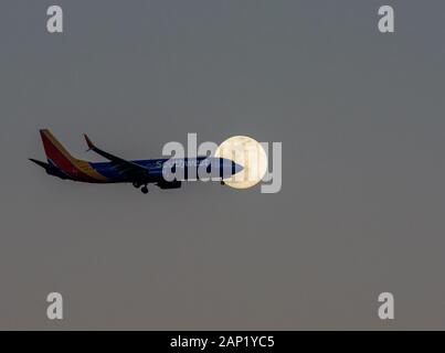 Un aereo Southwest Airlines atterra sotto una luna piena vicino all'Aeroporto Internazionale di Orlando o MCO. Foto Stock