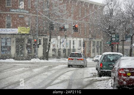 Il traffico su una coperta di neve suburban street durante una tempesta di neve Foto Stock