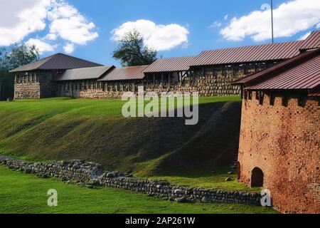 Frammento di un vecchio muro di fortificazione in pietra su un bastione di terracotta ricoperti di erba verde nella città di Kaunas in Lituania. Foto Stock