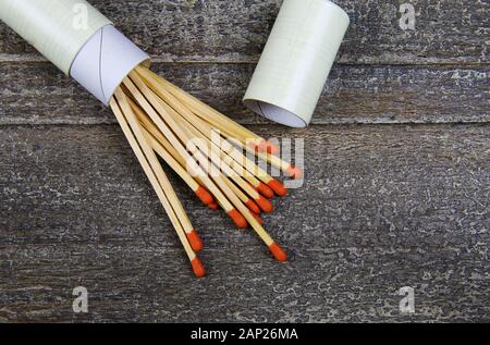 Protezione e prevenzione contro gli incendi concetto: gruppo isolato di fiammiferi in legno con teste rosse e round matchbox sulla tavola di legno Foto Stock