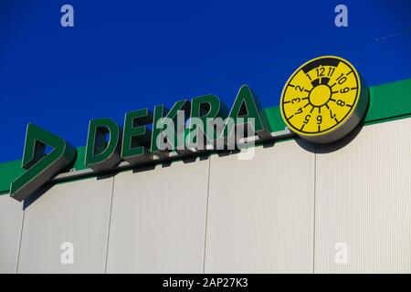 Dinslaken, Germania - 18 dicembre. 2019: logo verde e scritte di tedesco Società di revisione Dekra contro il cielo blu senza nuvole sul tetto di edificio Foto Stock