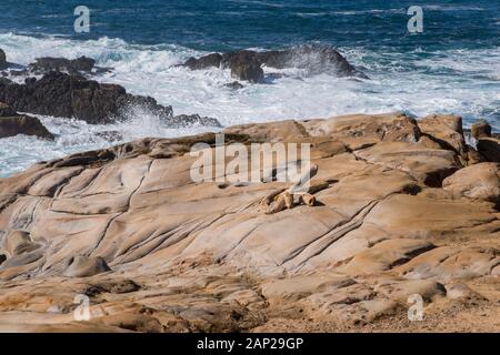 Le onde invernali blu si infrangono lungo la costa rocciosa del Pacifico della Riserva Naturale Statale di Point Lobos, California Foto Stock