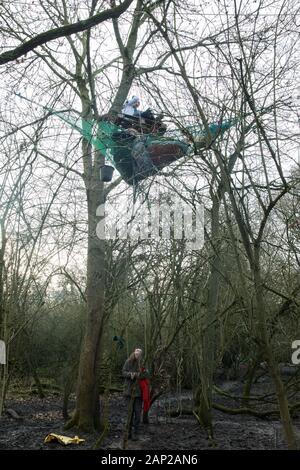 Harefield, UK. Il 20 gennaio, 2020. Un attivista sul terreno comunica con gli attivisti che vivono in alberi presso la strada Harvil la tutela della fauna selvatica camp. Estinzione della ribellione, Stop HS2 e salvare il Colne Valley aveva rioccupato il camp di due giorni prima come parte di un continuo tentativo di proteggere antichi boschi minacciato da HS2 collegamento ferroviario ad alta velocità dopo un piccolo gruppo di Stop HS2 attivisti erano stati sfrattati dagli ufficiali giudiziari nel corso delle due settimane precedenti. 108 antichi boschi sono impostati per essere distrutti mediante il collegamento ferroviario ad alta velocità. Credito: Mark Kerrison/Alamy Live News Foto Stock