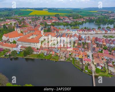 Veduta aerea di edifici colorati con tetti di tegole rosse nella piazza medievale e Castello Vecchio a Telc, Repubblica Ceca Foto Stock