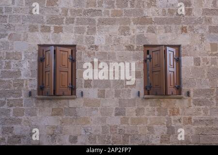 Due finestre in un vecchio edificio. Paesaggio urbano della città medievale all'interno di fortificazioni di Rodi. Foto Stock