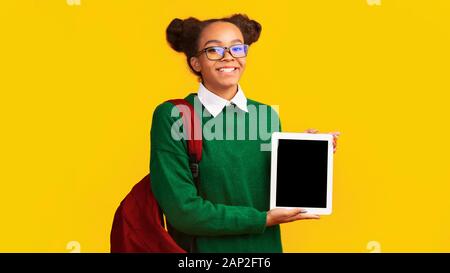 Sorridente African American teen presentando tavoletta digitale Foto Stock