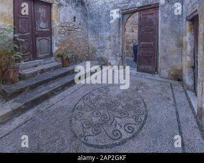 La donna guarda sul vecchio tempio nella città medievale all'interno di fortificazioni di Rodi. Foto Stock