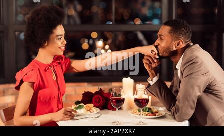 African American ragazzo ragazza baciare la mano risalente al ristorante, Panorama Foto Stock