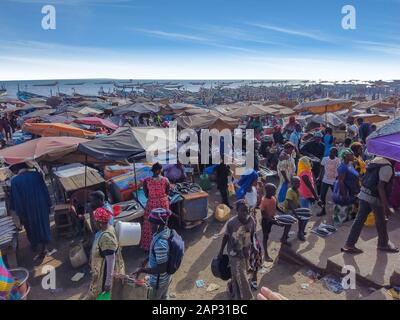 MBour, Senegal- 25 aprile 2019: Senegalesi non identificato di uomini e donne al mercato del pesce del porto della città nei pressi di Dakar. Ci sono bancarelle di vendita e Foto Stock