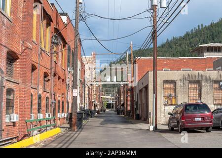 Una massa di fili elettrici e pali in un vicolo posteriore della storica città mineraria di Wallace, Idaho, USA Foto Stock