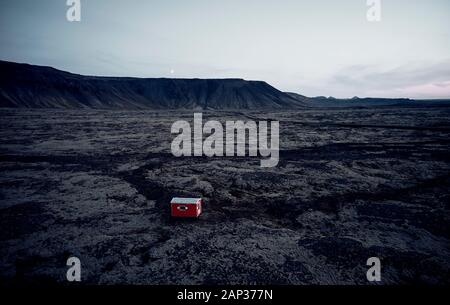 Da sopra luminosa casa rossa con tetto bianco nel deserto secco valle circondata da colline rocciose Foto Stock