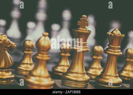 Il re in battaglia gioco di scacchi stare sulla scacchiera con nero sfondo isolato. Business leader del concetto di target di mercato strategia. Intelligenza cha Foto Stock