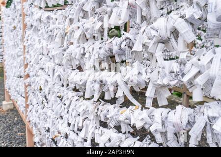 Saga, Giappone - nov. 12, 2018: giapponese random fortune raccontando carta (Omikuji) ripiegato e legato sulla corda fili (Omikuji kake) nel tempio tradizionale, conce Foto Stock