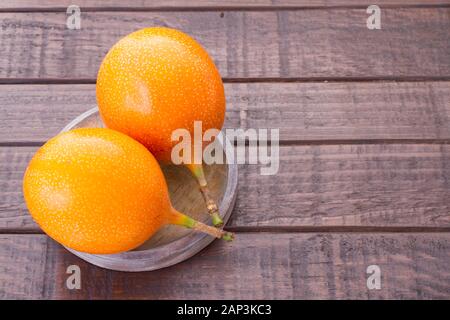 Il frutto della passione di granadilla sul tavolo - Passiflora ligularis Foto Stock