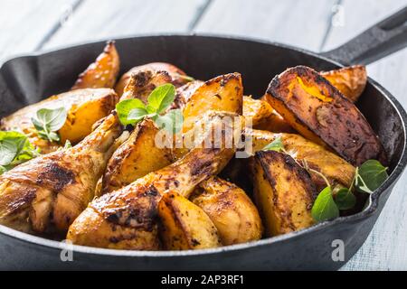 Arrosto di cosce di pollo in padella con patate americane e le erbe aromatiche Foto Stock