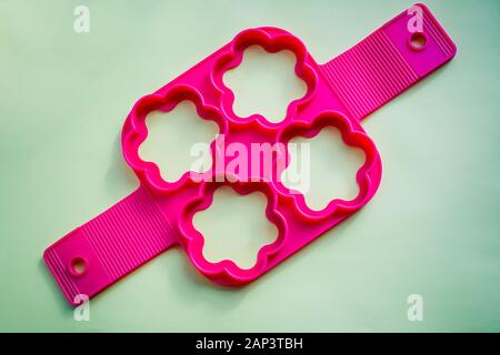 Stampi in silicone per la cottura in forno a forma di cuore e di strumenti per la cottura biscotti, focaccine e la torta su un bianco sullo sfondo di legno. Foto Stock