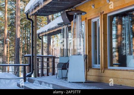 Lampada di riscaldamento collocato tra i tavoli di un cafe aperto Foto Stock