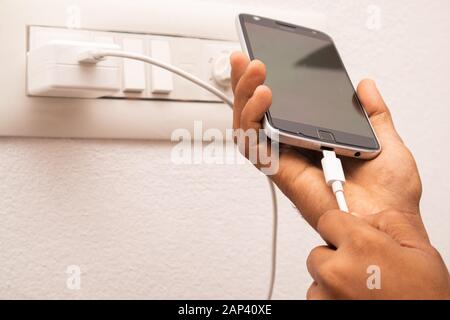 Maski, India 18, gennaio 2020 - smartphone con presa A Mano e cavo di ricarica USB di tipo C collegato al cellulare per la ricarica. Foto Stock