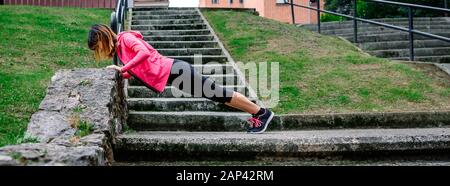 Atleta femminile che fa i push-up all'aperto Foto Stock