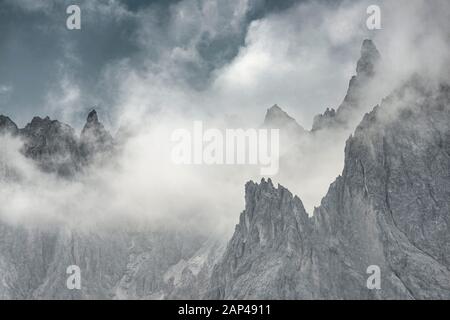 Bizzarre cime montuose con nuvole drammatiche, Cimon di Croda liscia e Cadini Group, Dolomiti Sexten, Belluno, Italia Foto Stock