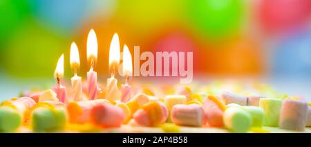 Banner festivo colorato compleanno con cinque candele brucianti sulla torta e palloncini colorati sullo sfondo. Spazio per il testo di congratulazioni Foto Stock