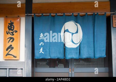 Negozio tradizionale giapponese a Takayama, Prefettura di Gifu, Giappone, la tenda porta un'identificazione della cresta del mon (o kamon) Foto Stock