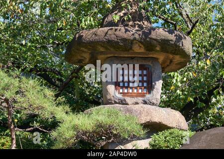 La vista della lanterna di pietra giapponese Nazura-doro fatta con pietre ruvide e non lucidate nel Tempio Isshin-ji di Osaka. Giappone Foto Stock