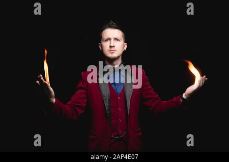 Mago mostra trick con fuoco ustione dalle mani di palme Foto Stock