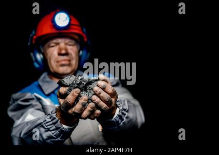 Il minatore mani sporche holding pezzo di miniera di carbone Foto Stock