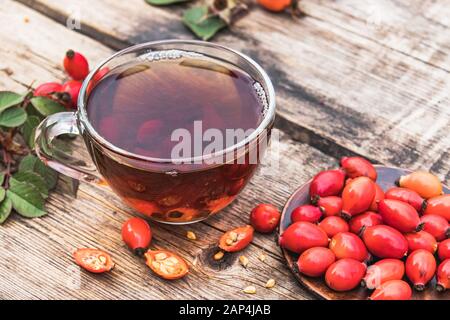 Una tazza di tè al rosato con frutti di bosco freschi su un tavolo di legno. Fitoterapia. Foto Stock