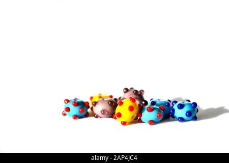 Bellissimo sfondo colorato e allegro fatto a mano di perle di lampwork con punti. Le perle sono isolate su sfondo bianco. Adatto per inserto di testo. Foto Stock