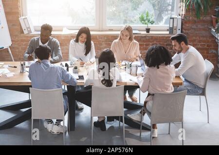 Gruppo di persone che discutono di idee aziendali al briefing mattutino Foto Stock
