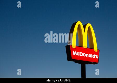 McDonalds segno o logo, illuminato contro un cielo blu scuro al crepuscolo, Lincolnshire Regno Unito Foto Stock