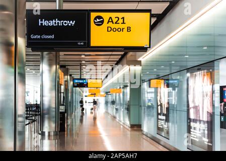 London, Heathrow Airport, Aug 2019: Segni gialli all'aeroporto con numero di gate. Cartello cancello chiuso Foto Stock