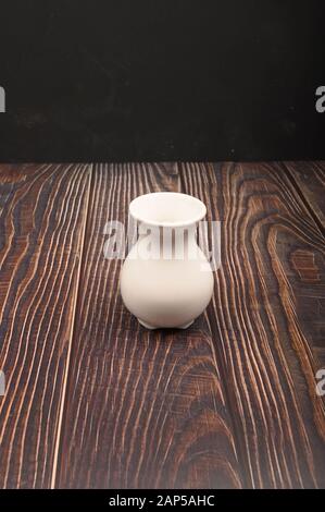 Vaso in ceramica bianca in stile cinese su sfondo di legno. Primo piano Foto Stock