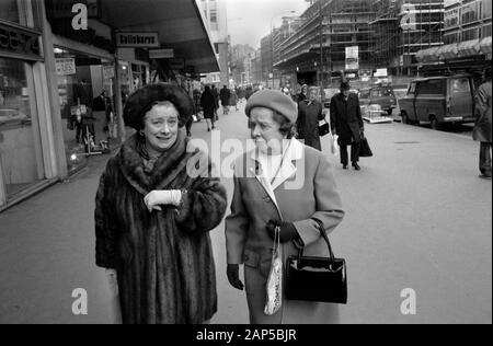 Cappotto in pelliccia 1970s UK. Due donne di mezza età vestite in modo elegante per fare shopping, una indossa un cappotto di pelliccia. Camminando in Victoria Street. Victoria, Londra Inghilterra 1976. HOMER SYKES Foto Stock