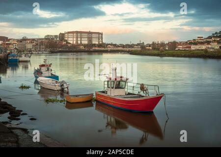 Vista del fiume Ave a Vila do Conde, Portogallo, con barche da pesca ancorate in primo piano e il convento di Santa Clara sullo sfondo. Foto Stock