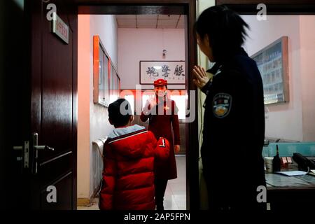 (200121) -- SHIJIAZHUANG, Gennaio 21, 2020 (Xinhua) -- Li Qi (C) rende il suo figlio Zhang Anzhe aspettare per suo padre Zhang Peng presso la locale stazione di polizia in Shijiazhuang, a nord della Cina di nella provincia di Hebei, Gennaio 21, 2020. La festa di primavera è la più grande occasione per il ricongiungimento familiare in tutta la Cina, ma anche per la famiglia di 6-anno-vecchio Zhang Anzhe, reunion opportunità sono rare. Zhang il padre Zhang Peng è un poliziotto lavora a Shijiazhuang Stazione ferroviaria ufficio di polizia mentre la madre li Qi è un direttore principale sui treni tra Shijiazhuang e Wuhan. Entrambi i genitori erano così occupati durante la primavera Festiva Foto Stock