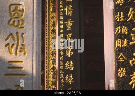 Scrittura golden chinese sulle colonne di un tempio buddista cinese situato a Saigon, Vietnam (ho Chi Minh City) Foto Stock