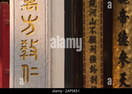 Scrittura golden chinese sulle colonne di un tempio buddista cinese situato a Saigon, Vietnam (ho Chi Minh City) Foto Stock