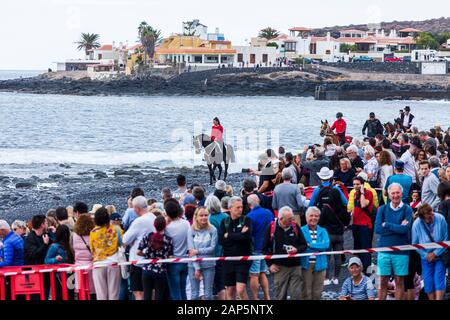 Una folla di persone in attesa per l arrivo dei cavalli sulla spiaggia di San Sebastian fiesta in La Caleta, Costa Adeje, Tenerife, Isole Canarie. Foto Stock